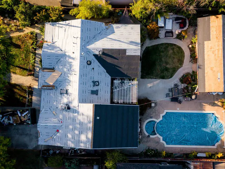 Drone view of a Hamilton re-roof in progress, underlayment down across the main house