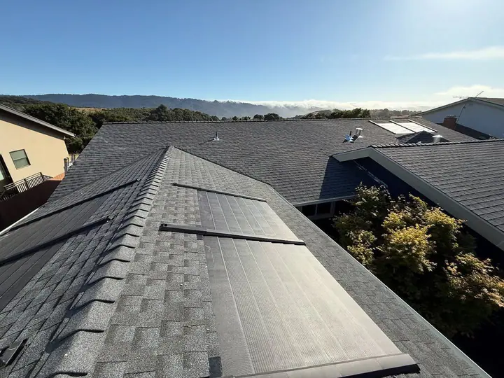 Dark shingle roof with integrated solar above coastal fog
